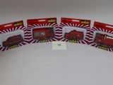 Quatre camions rouges miniatures sont alignés sur une surface blanche