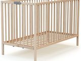 un berceau en bois avec une armature métallique sur fond blanc