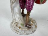 a figurine of a man holding a ball on a table