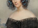 portrait of a woman in a black dress with a blue flower in her hair