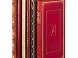 several books are stacked on top of each other on a white surface