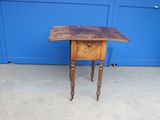 une petite table avec un plateau en bois posée sur un trottoir
