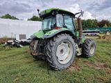 un tracteur vert garé dans l'herbe