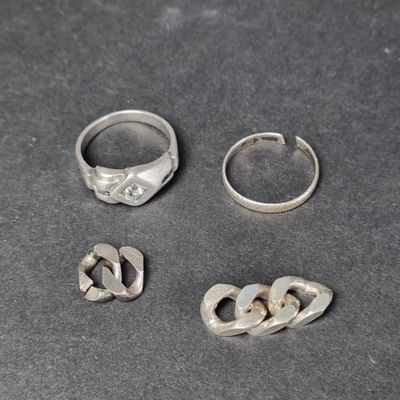 trois anneaux en argent et deux anneaux en argent sur un fond noir