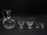five glasses and a decanter on a table