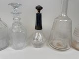 many different glass bottles sitting on a white surface