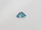 a blue topaze trillion cut diamond on a white surface