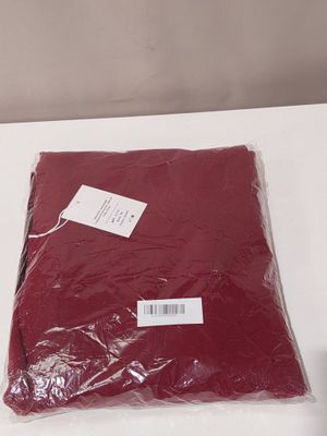 a bag of red cloth on a table next to a bottle of wine