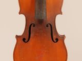an old violin sitting on top of a white surface