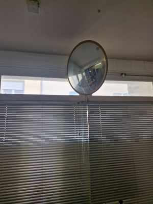 un miroir accroché au mur au-dessus d'une fenêtre dans une salle de bains