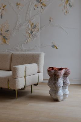 un canapé et un fauteuil dans une pièce dont l'un des murs est tapissé