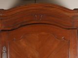 a wooden armoire with a clock on top of it