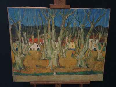 a painting on a easel with a painting of a village in the background