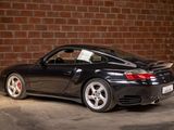 a black sports car parked in front of a brick wall