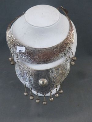 une théière ancienne en métal argenté avec couvercle, posée sur un socle