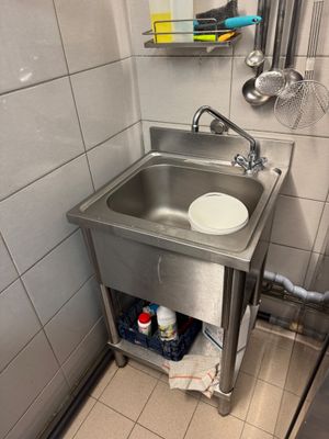 a sink in the corner of a bathroom with a mirror above it