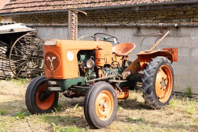 un vieux tracteur qui est à l'abandon dans l'herbe