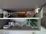 a shelf with dishes and glasses on it in the kitchen