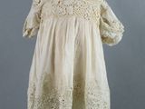 a white dress on a mannequin stand with a gray background