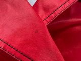 a close up of a red jacket with black stitching on it