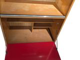 a red mat on the floor next to a wooden shelf