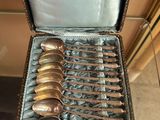 silverware in a case with a silver handle and spoons in it