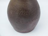 a brown vase with writing on it sitting on a table
