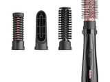 un gros plan sur trois types différents de brosses à cheveux sur fond blanc
