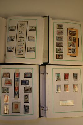 trois pages d'un livre, sur lesquelles sont apposés des timbres, posées sur une table