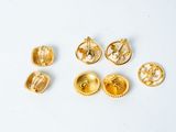 a close up of a group of gold jewelry on a white surface