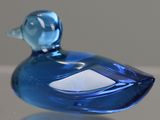 a blue glass duck that is sitting on a table