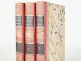 trois livres superposés sur une surface blanche