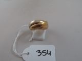 une bague en or sur une étiquette blanche avec une étiquette de prix