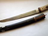 a knife that is laying next to a knife on a table