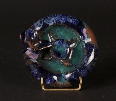 a picture of a blue and green plate on a stand