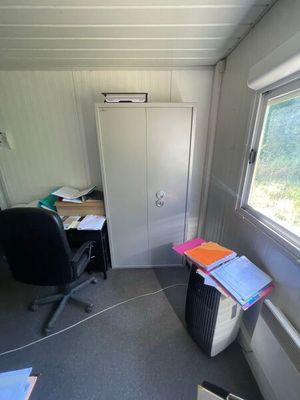 une pièce dans laquelle se trouvent un bureau, une chaise et une armoire