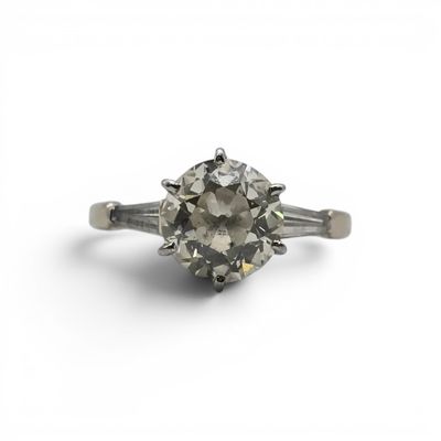 a close up of a diamond ring on a white surface