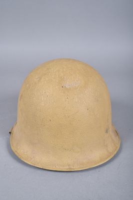 un vieux casque est posé sur une table à fond gris