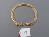 an image of a gold bracelet with a tag attached to it