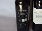 two bottles of wine sitting next to each other on a table