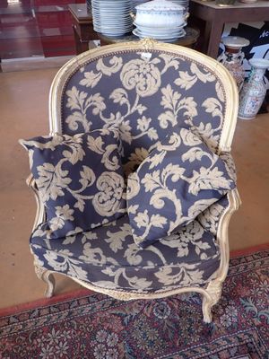 a blue and white chair with pillows on it in a room