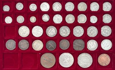 un assortiment d'objets en argent et de pièces d'argent présentés dans une vitrine rouge