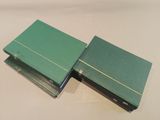 two green books sitting on top of each other on top of a table