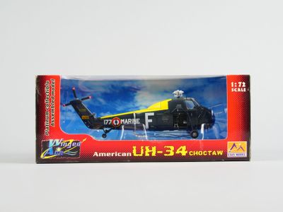 maquette d'un hélicoptère noir dans une boîte posée sur une surface blanche