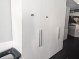 an image of a room with white cabinets and a black chair
