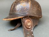 an old helmet is sitting on a table on a gray surface