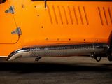 a close up of an orange car parked in a garage
