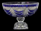 an image of a blue glass bowl on a stand on a black background