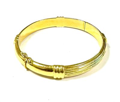 a close up of a gold bracelet on a white surface