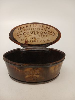 une vieille boîte en bois avec une inscription dessus, posée sur une surface blanche